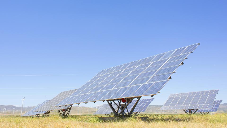 Solarpaneele und Windräder auf einem Feld